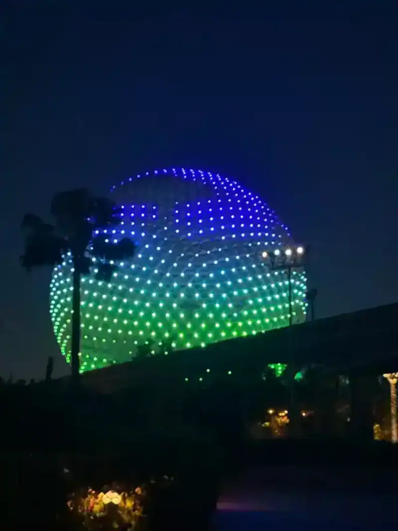 Epcot Globe at night, which can be viewed on a budget by using points and cash back apps.